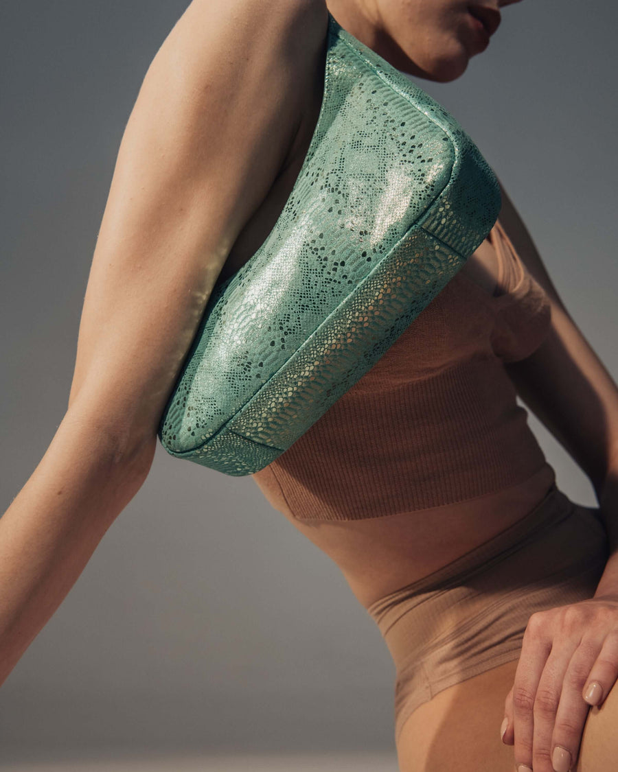 View of Zoe mini baguette bag in green snake like leather.