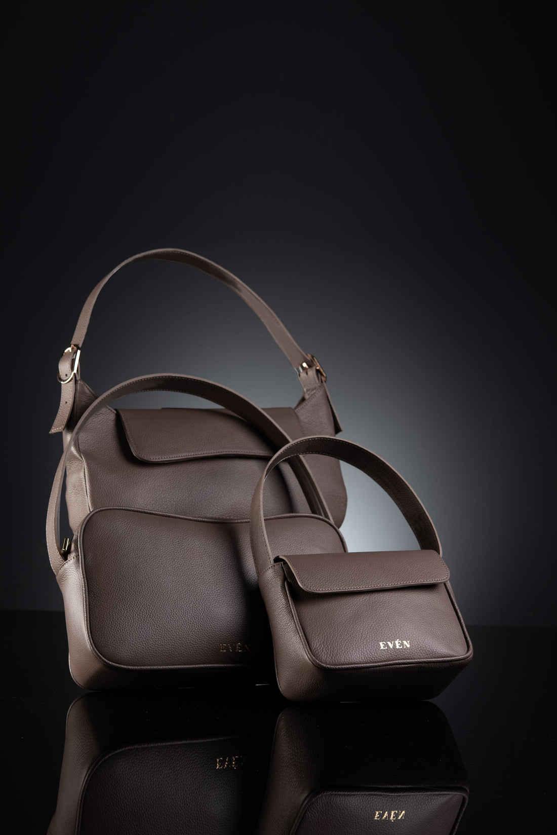 Stylish collection of brown handbags on a reflective surface against a dark background.