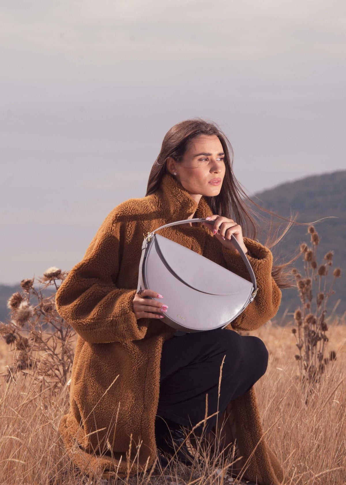 Model showing Gaia mini bag in heather gray leather 