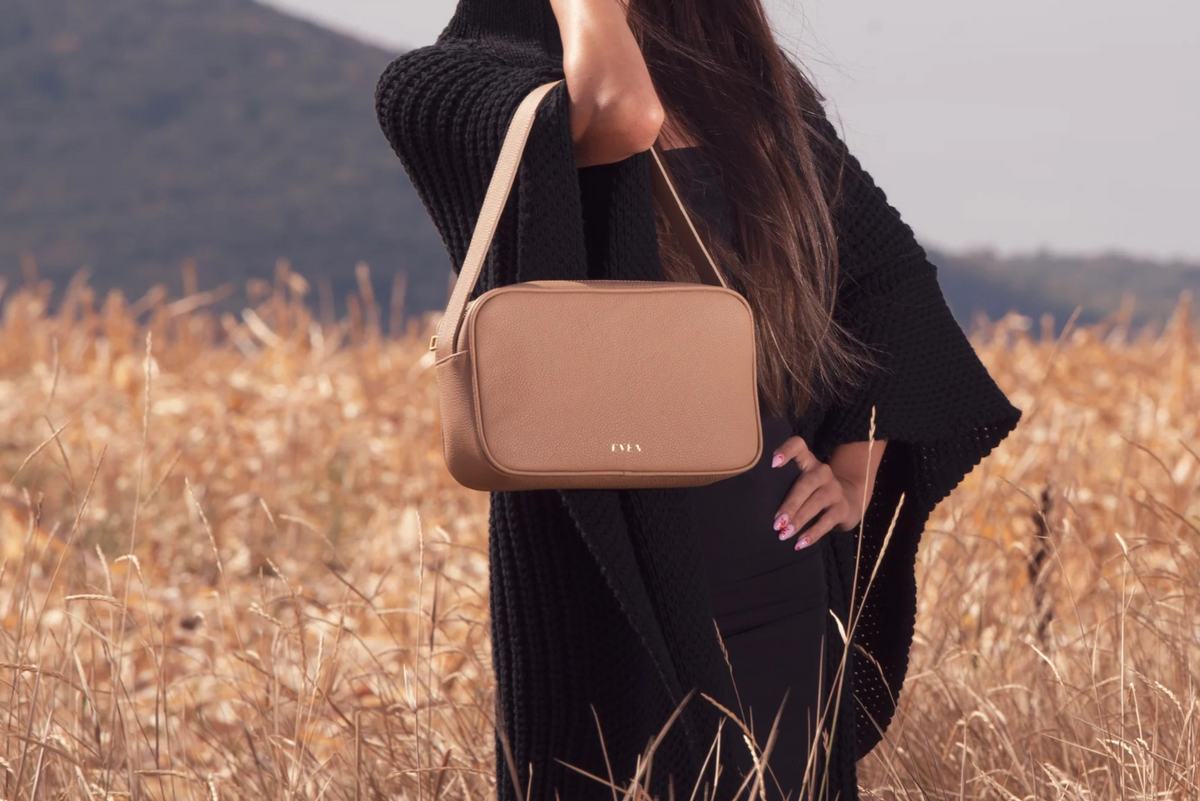Woman wearing Rhea beige leather messenger bag in autumn field by even-online