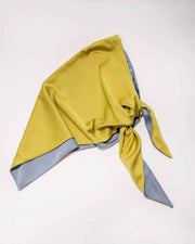 A double-sided satin head scarf with one side olive and the other side blue, tied in a knot.
