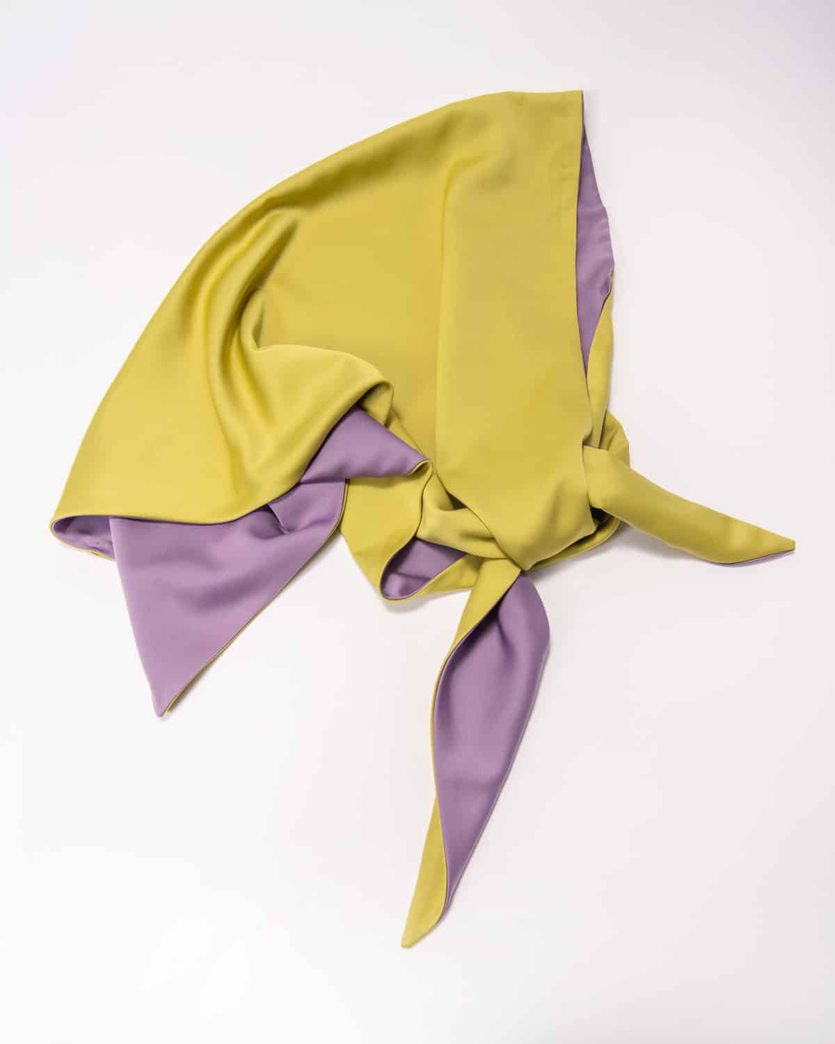 A double-sided satin head scarf with one side in olive green and the other in purple, laid out on a white background.