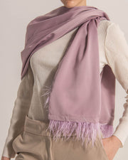 Woman wearing pink satin scarf on top of cream color top.