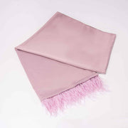 A long pink satin scarf with ostrich feather fringe laid out on a plain surface.