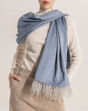 Long blue satin scarf wrapped around a model wearing light cream top.