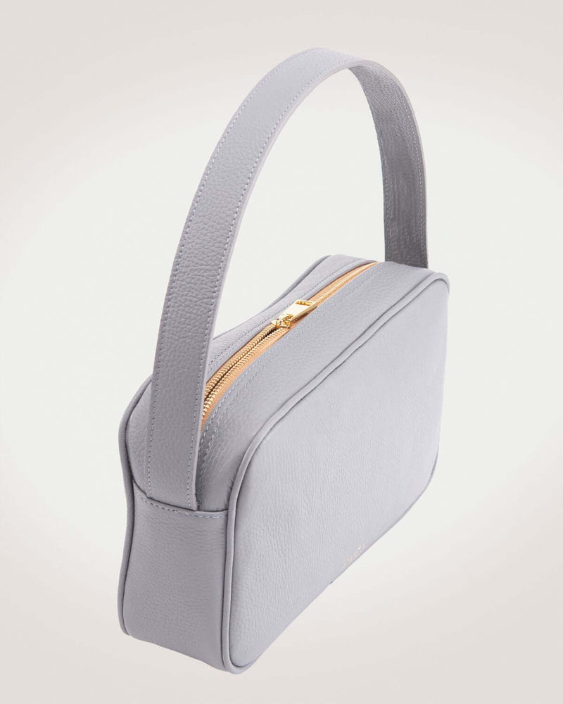 Rhea messenger bag in gray leather with gold tone zipper.
