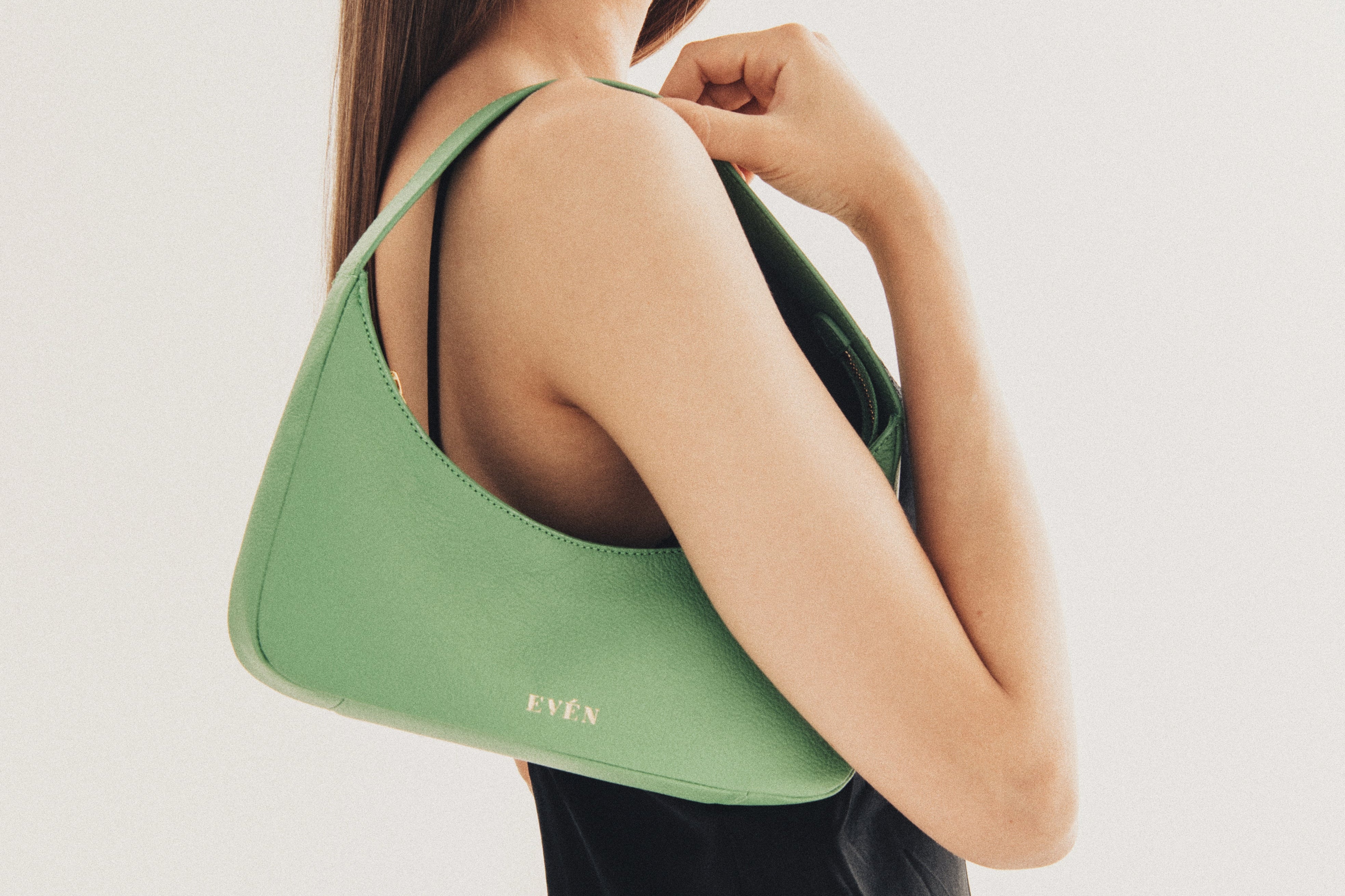 Model wering even logo green mini baguette purse