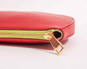 Leyza clutch in red leather with gold tone zipper.