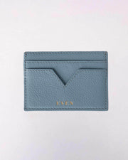 Blue leather cardholder with gold logo on a light gray background