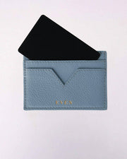 Grey cardholder with a black card on a light gray background
