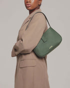 model is wearing valenta mini baguette bag in dark green with gold-tone even logo