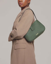 model is wearing valenta mini baguette bag in dark green with gold-tone even logo
