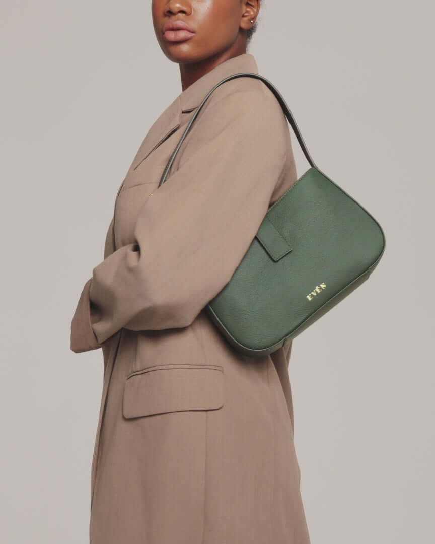 model is wearing valenta mini baguette bag in dark green with gold-tone even logo