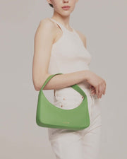 Model showing Zoe mini baguette bag in green leather by even-online
