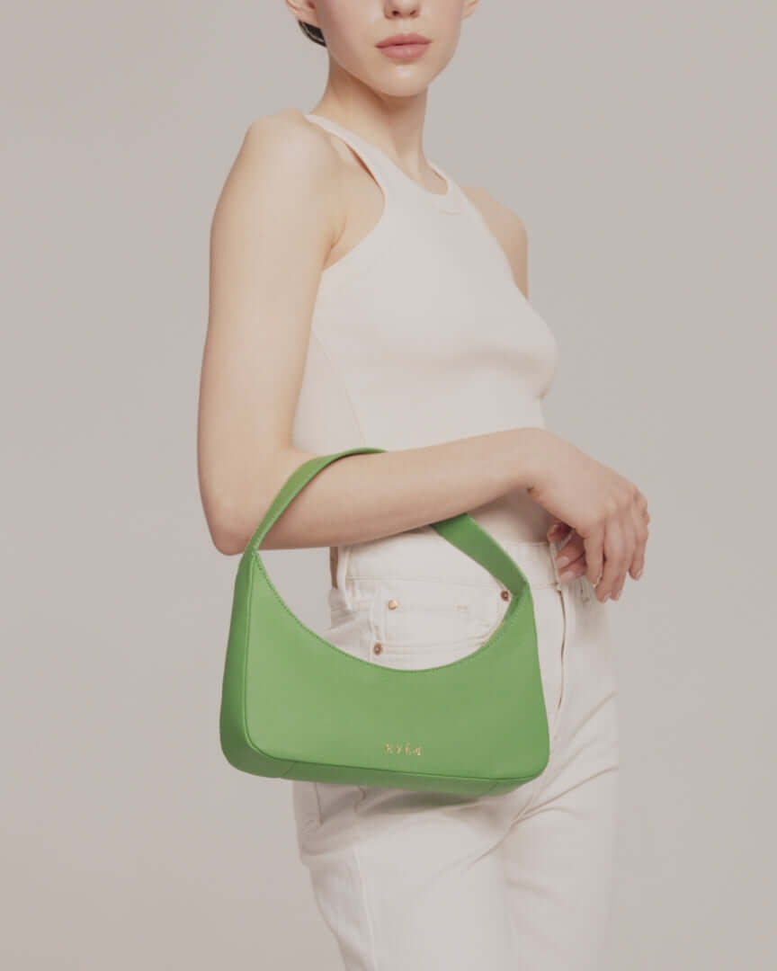 Model showing Zoe mini baguette bag in green leather by even-online