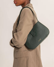 Model wearing Valenta mini baguette bag in dark green leather by even-online.