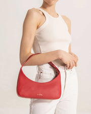Woman showing Zoe mini baguette bag in red leather by even-online