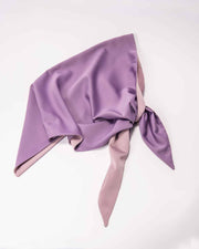 A double-sided satin head scarf with purple and pink colors laid out on a flat surface.