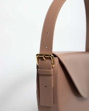 Side view of GAIA Mini Bag in beige with gold tone hardware and adjustable strap.
