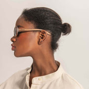 Model wearing wooden frame sunglasses with EVEN logo engraved on the frame