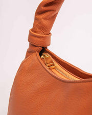 Monna orange leather handbag gold tone zipper with twisted leather handle.