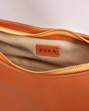 Orange leather handbag interior with gold zipper and EVEN brand logo on beige lining