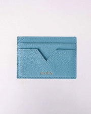 A light blue Muzi cardholder made from premium calfskin leather, displayed on a white background with gold tone logo.